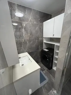 a bathroom with a sink and a washing machine at Apartments Lux in Spodnja Hajdina