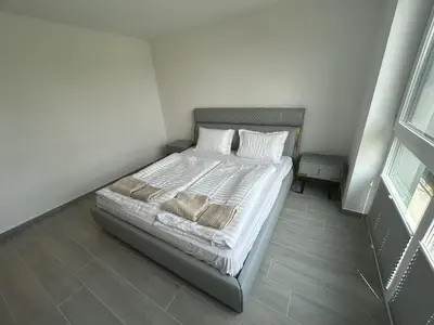 a bedroom with a bed with white sheets and pillows at Apartments Lux in Spodnja Hajdina