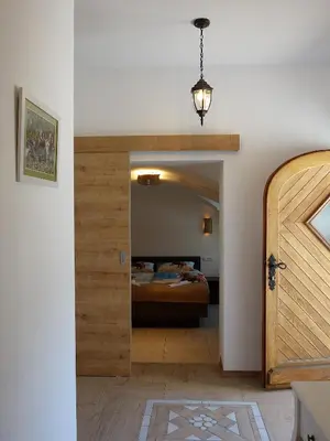 a bedroom with a bed and a door leading into a room at Apartmaji Pri fijakarju - Apartments 