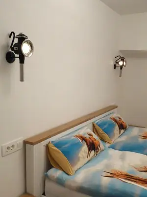 a bedroom with two beds and a light on the wall at Apartmaji Pri fijakarju - Apartments 