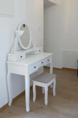 a white dressing table with a mirror and a stool at Apartmaji Pri fijakarju - Apartments 