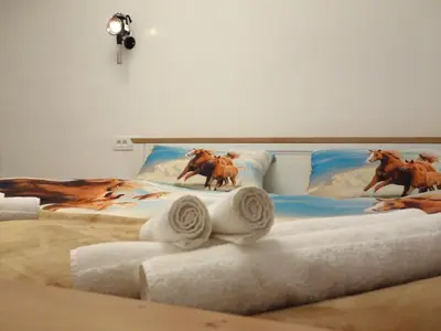 a bed with a painting of horses on it at Apartmaji Pri fijakarju - Apartments 