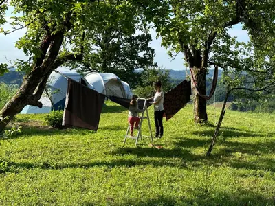 a man and a child standing in front of a tent at Nature-based Retreat by Naj Raste in Senovo