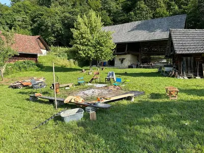 a yard with furniture and a building in the grass at Nature-based Retreat by Naj Raste in Senovo