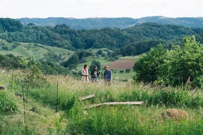 a group of three people walking in a field at Nature-based Retreat by Naj Raste in Senovo