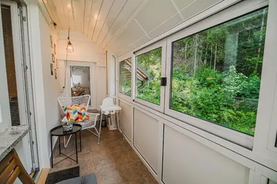 a small room with two windows and a chair at Apartment Marni w/ Parking | Kranjska Gora in Kranjska Gora