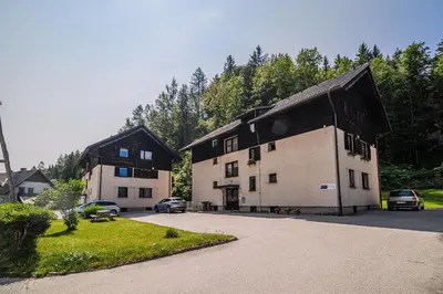 a couple of buildings with cars parked in a parking lot at Apartment Marni w/ Parking | Kranjska Gora in Kranjska Gora