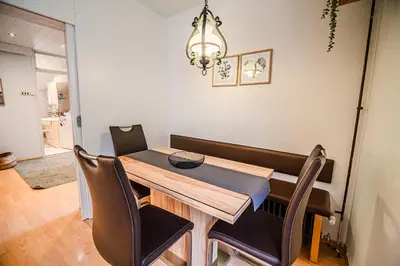a dining room table with chairs and a chandelier at Apartment Marni w/ Parking | Kranjska Gora in Kranjska Gora