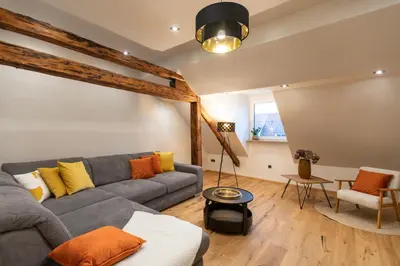 a living room with a gray couch and orange pillows at Gris Apartment in Gornja Radgona
