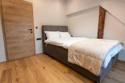 a bedroom with a bed and a wooden door at Gris Apartment in Gornja Radgona