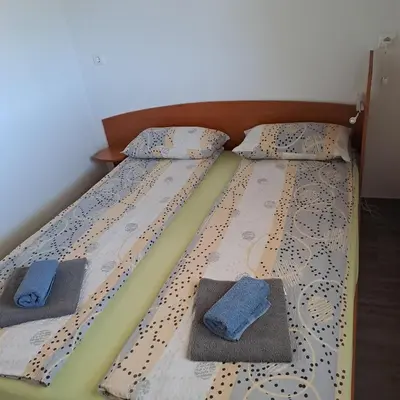 two beds with pillows and towels on them in a bedroom at Apartma Kolpa Krasinec in Gradac
