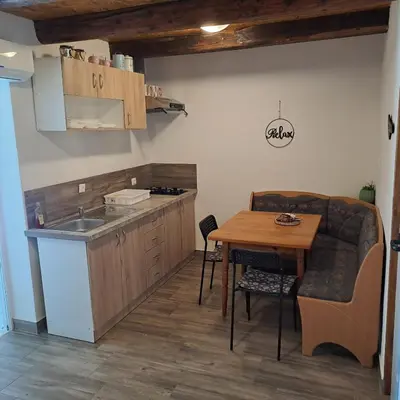 a kitchen and dining room with a table and a sink at Apartma Kolpa Krasinec in Gradac