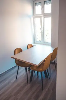 a table and chairs in a room with a window at Maribella Apartment in Maribor