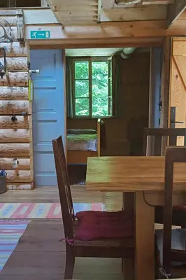 a dining room with a wooden table in a cabin at Loghouse cabin in the Kočevje forest in Kočevje