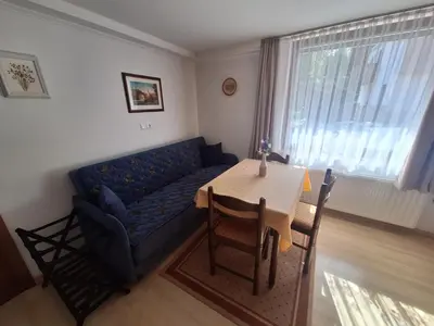 a living room with a blue couch and a table at Apartma P&B in Bled