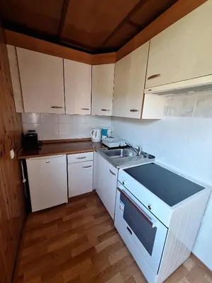 a kitchen with white cabinets and a sink at Apartma P&B in Bled