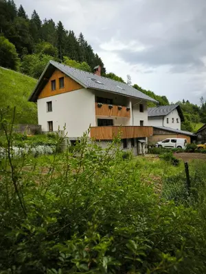 a white and orange house in the middle of a field at Brlog 2 in Zgornje Gorje