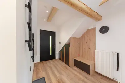 an attic hallway with a black door and wooden floors at Brlog 2 in Zgornje Gorje