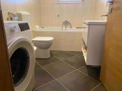 a bathroom with a washing machine and a toilet at Apartment9B in Krško