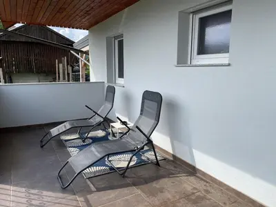 two chairs sitting next to a wall on a patio at Apartment9B in Krško