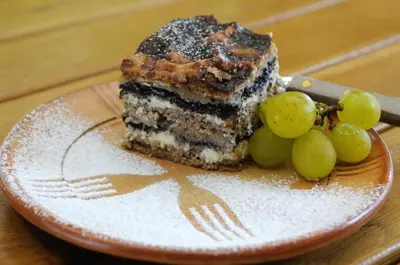 a piece of cake on a plate with grapes at Chonky Cat in Moravske Toplice