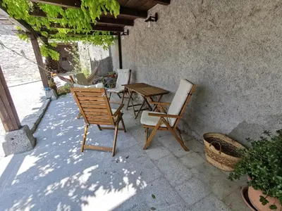 a patio with chairs and a table and a table and chairs at Domus Carstica in Sežana