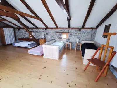 a large attic room with a bed and a chair at Domus Carstica in Sežana