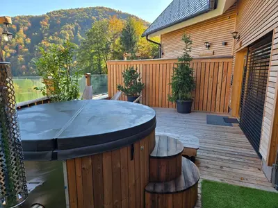 a patio with a table and benches on a deck at Savinjski raj in Mozirje