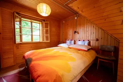 a bedroom with a large bed in a wooden cabin at Koča na Lazu in Ajdovščina