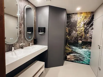 a bathroom with two sinks and a painting on the wall at Central Hostel Lesce-Bled in Lesce