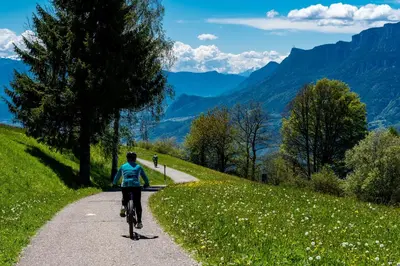 a person riding a bike on a path in the mountains at Barbana Lipizzans Camper Park - Pitches for Campers and Tents in Radovljica