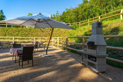 a patio with an umbrella and a table and chairs at Barbana Lipizzans Camper Park - Pitches for Campers and Tents in Radovljica
