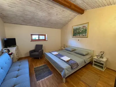 a bedroom with a bed and a chair and a couch at Omnia rooms in Sežana