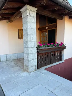 a window of a house with pink flowers on a balcony at Omnia rooms in Sežana