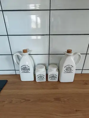 four white vases sitting on top of a wooden floor at Hiša Šturm in Tolmin