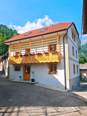 a white building with a balcony on a street at Hiša Šturm in Tolmin