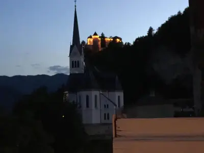 a church with a steeple on top of a building at Lake and Castle view apartment in Bled