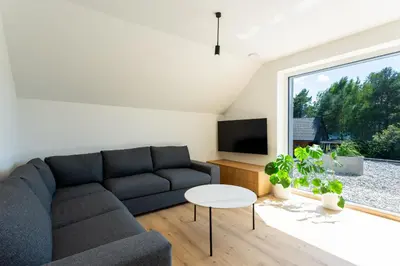 a living room with a couch and a tv at Sunny Green Escape - Apartment with Terrace in Lesce
