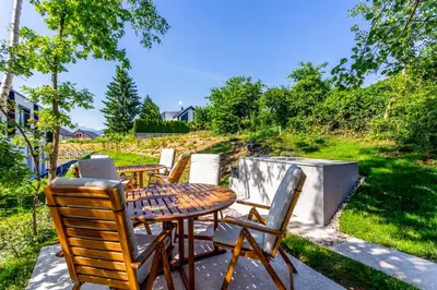 a patio with a wooden table and chairs at Sunny Green Escape - Apartment with Terrace in Lesce