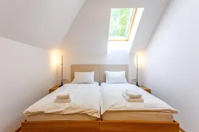 a bedroom with two beds with white sheets and a window at Sunny Green Escape - Apartment with Terrace in Lesce