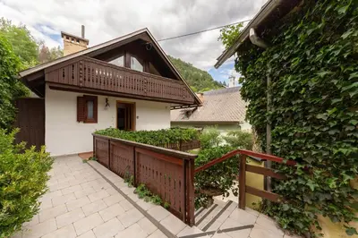 a small house with a balcony and a fence at Happy Brook Bled in Bled