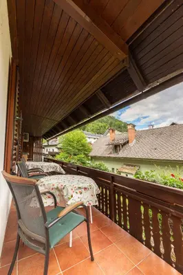 a balcony with a table and a chair on a deck at Happy Brook Bled in Bled