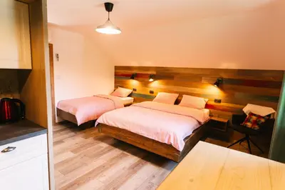a bedroom with two beds and a desk with a chair at Homestead Lukec Studio Apartments - Archery, BBQ, Escape Room, Kayaking in Kostel