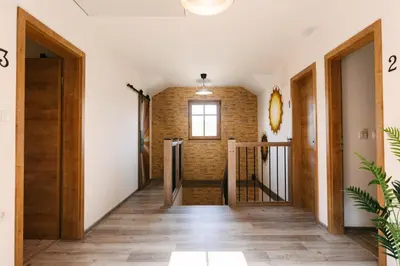 a hallway with wooden floors and a brick wall at Homestead Lukec Studio Apartments - Archery, BBQ, Escape Room, Kayaking in Kostel