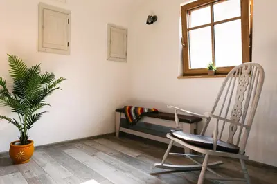 a room with a chair and a bench and a plant at Homestead Lukec Studio Apartments - Archery, BBQ, Escape Room, Kayaking in Kostel
