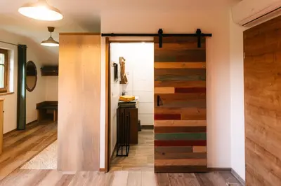 a sliding barn door in a room with wood at Homestead Lukec Studio Apartments - Archery, BBQ, Escape Room, Kayaking in Kostel