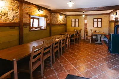 a dining room with a long wooden table and chairs at Homestead Lukec Studio Apartments - Archery, BBQ, Escape Room, Kayaking in Kostel