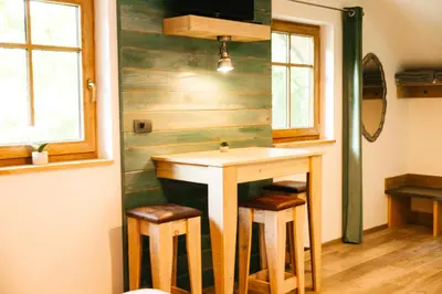 a bathroom with a table and two stools at Homestead Lukec Studio Apartments - Archery, BBQ, Escape Room, Kayaking in Kostel