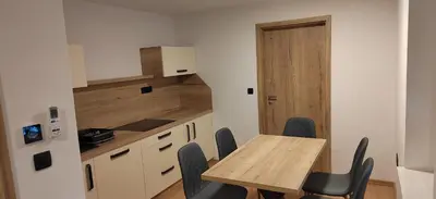 a small kitchen with a wooden table and chairs at MaxLux Apartments in Slovenj Gradec
