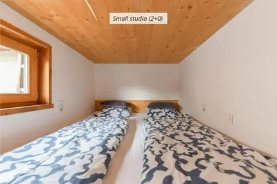 two beds in a small room with a window at IQ wood apartment in Ljubljana